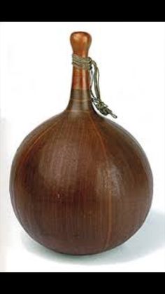 a wooden vase with a rope on the top and bottom, sitting in front of a white background