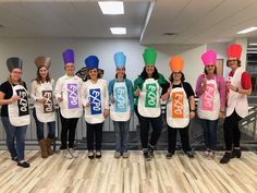 a group of people standing next to each other wearing aprons with letters on them