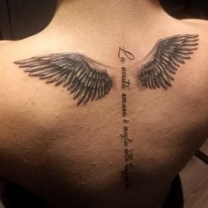 the back of a man's shoulder with two wings and an inscription on it