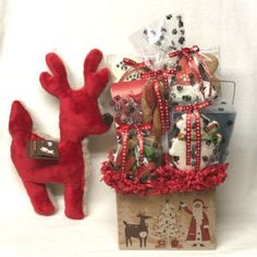 a red stuffed animal sitting next to a gift bag