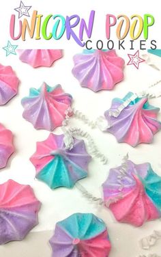 unicorn pop cookies on a white plate with pink, blue and purple icing in the shape of umbrellas