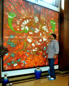 a man standing in front of a large painting