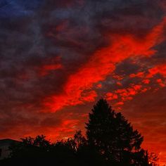 the sky is red and orange as it appears to be very cloudy in the evening