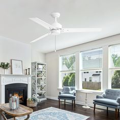 a living room filled with furniture and a fire place in front of a window covered in blinds