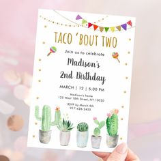 a person holding up a birthday card with cacti in pots and bunting flags