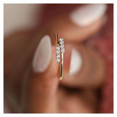 a woman's hand holding a diamond ring in front of her face and the other hand behind her