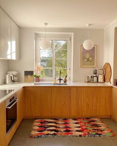 a kitchen with wooden cabinets and an area rug