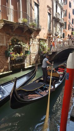 two gondolas are tied to the side of a canal in venice, italy