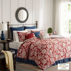 a bed with red and blue comforters in a bedroom