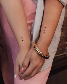 a woman with two small black dots on her arm