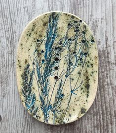 a white plate with some blue plants on it