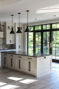 a large kitchen with an island in the middle and lots of windows on both sides