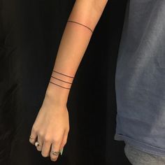 a woman's arm with a single line tattoo on it