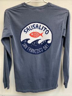 That moment a fish leaves the briny San Francisco Bay and finds itself momentarily airborne above the waves.100% cotton garment dyed long sleeve shirt will shrink no further with washing. Large back print and right hand breast small print. Shirt made by Comfort Colors. Blue Soft-washed Long Sleeve T-shirt, Long Sleeve Washed Cotton T-shirt, Long Sleeve Washed T-shirt For Fall, Long Sleeve Washed T-shirt Relaxed Fit, Long Sleeve Washed Relaxed Fit T-shirt, Washed Cotton Long Sleeve T-shirt, Long Sleeve Cotton T-shirt For Surfing, Small Print, San Francisco Bay