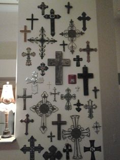 a wall with many crosses on it and a lamp in the corner next to it