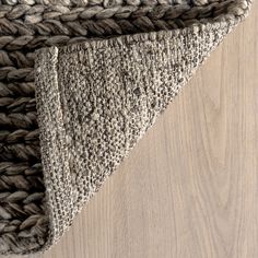 an area rug with a triangle shaped design on the top and bottom, in light brown tones