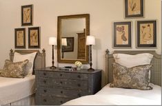 a bedroom with two twin beds and pictures on the wall above them, along with an antique dresser