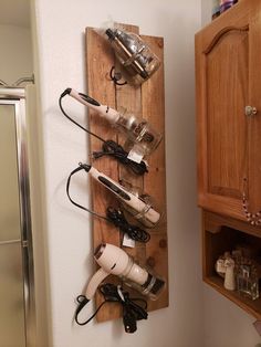 a wooden rack with hair dryers and other items hanging on it's side