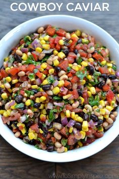 a bowl filled with black eyed peas, corn and cilantro salsa on top of a wooden table