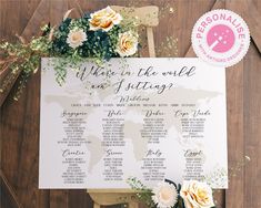 a wedding seating chart with flowers and greenery sits on top of a wooden table