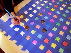 someone is painting squares on a piece of paper