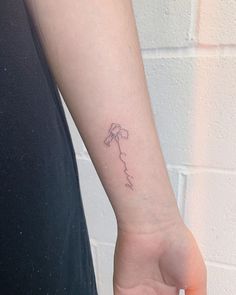 a woman's arm with a small flower tattoo on the left side of her wrist