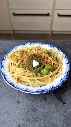 pasta with broccoli and cheese on a blue and white plate in the kitchen