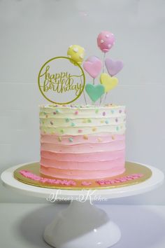 a birthday cake with pink, white and yellow frosting