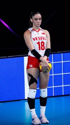 a female volleyball player holding a ball and glove