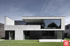 a modern house with large windows and grass