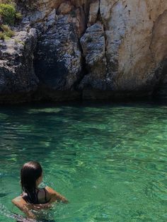 a woman is swimming in the clear blue water