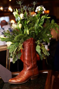 a boot with flowers in it sitting on a table