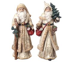 two figurines of santa claus holding christmas tree and watering can, both wearing white robes