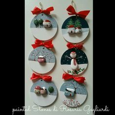 four christmas ornaments hanging on a wall with red bows and ribbons around the top of each ornament