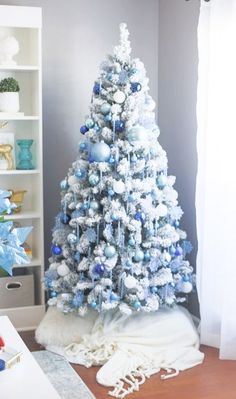 a blue and white christmas tree in a living room