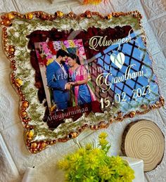 a wedding photo is displayed on the wall next to a vase with flowers and a potted plant