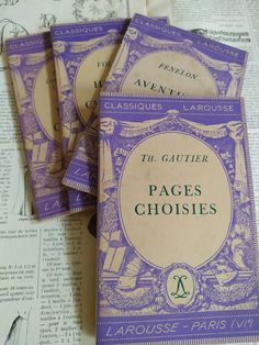 three purple books sitting on top of a table next to an open book with the title'the gutter pages choices '