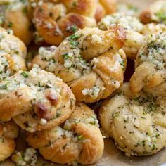 a plate full of small pastries with cheese and herbs on top, ready to be eaten