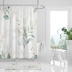 a white bathroom with a shower curtain and potted plant