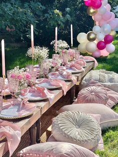 a table set up with pink and white balloons