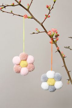 two ornaments hanging from a tree branch with flowers