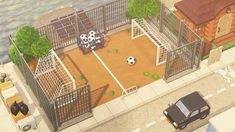 an aerial view of a fenced in area with soccer balls on the ground and cars parked nearby