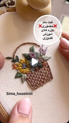 someone is stitching flowers in a basket