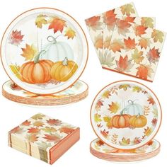 a set of thanksgiving dinnerware with pumpkins and leaves on the plates, napkins and place mats