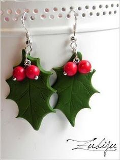 holly leaf earrings with red berries hanging from them