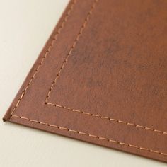 a piece of brown leather with stitching on it