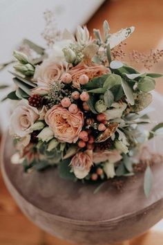 a bouquet of flowers sitting on top of a stool