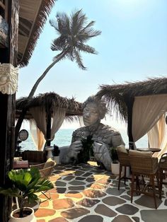 an outdoor area with tables and chairs near the ocean