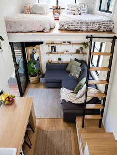 a small living room with stairs leading to the top floor and loft bed above it