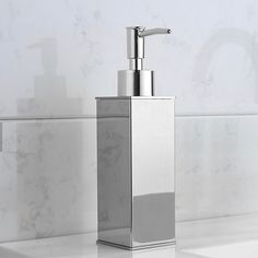 a silver soap dispenser sitting on top of a white counter